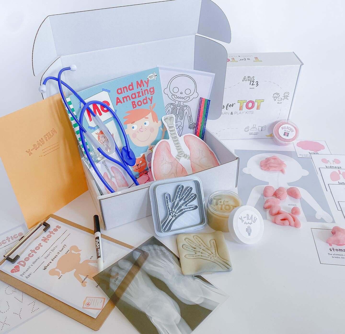 Play and learn kit for kids aged 3-6 focused on the human body. Features a book, x-ray images, homemade playdough, a lung experiment, organ placement mat, and a real working stethoscope.