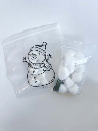 Child assembling a snowman using cotton balls in the Snowman Bag Activity from the baking kit.