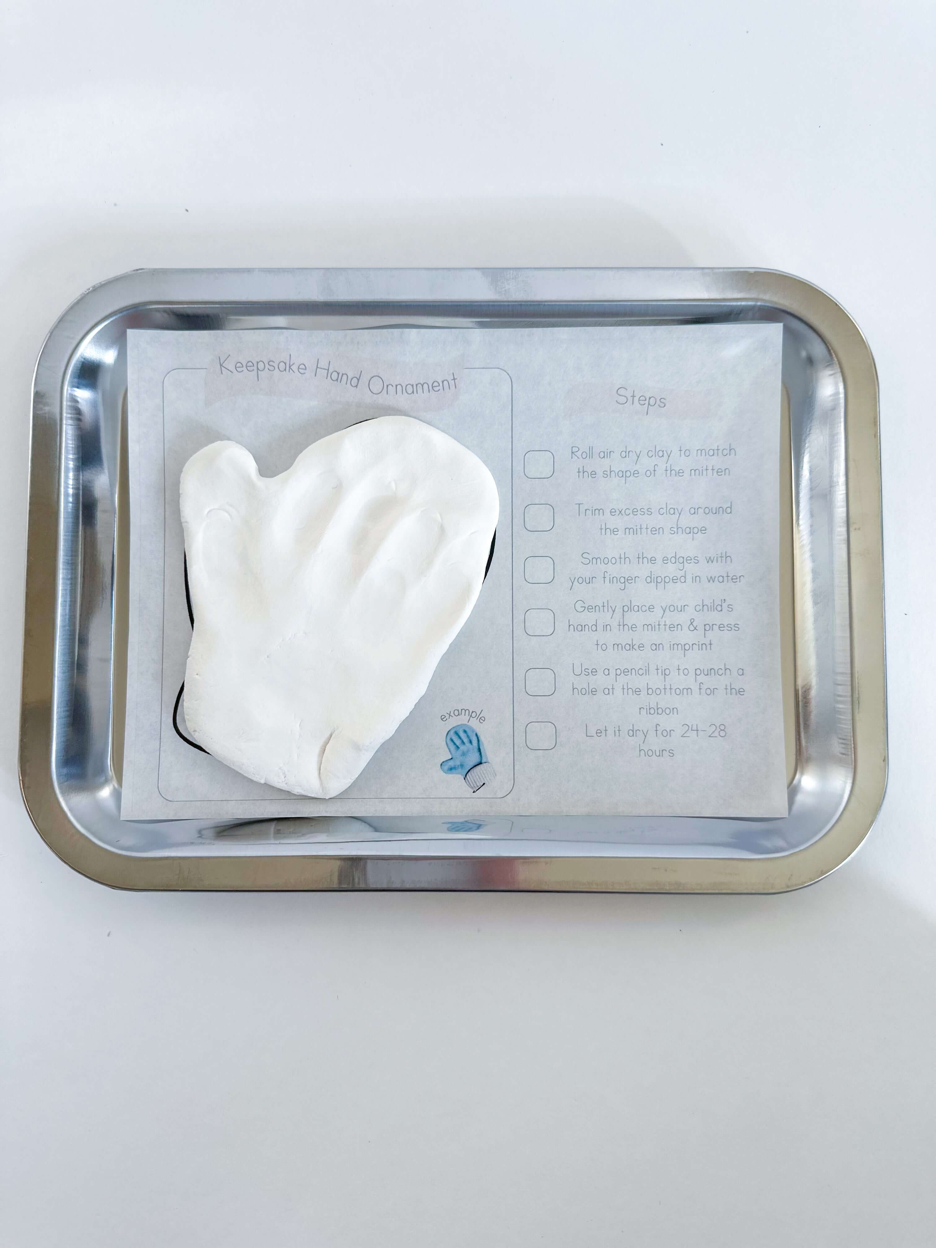 Child creating a handprint ornament with air-dry clay from the Frosty Fun Baking Kit