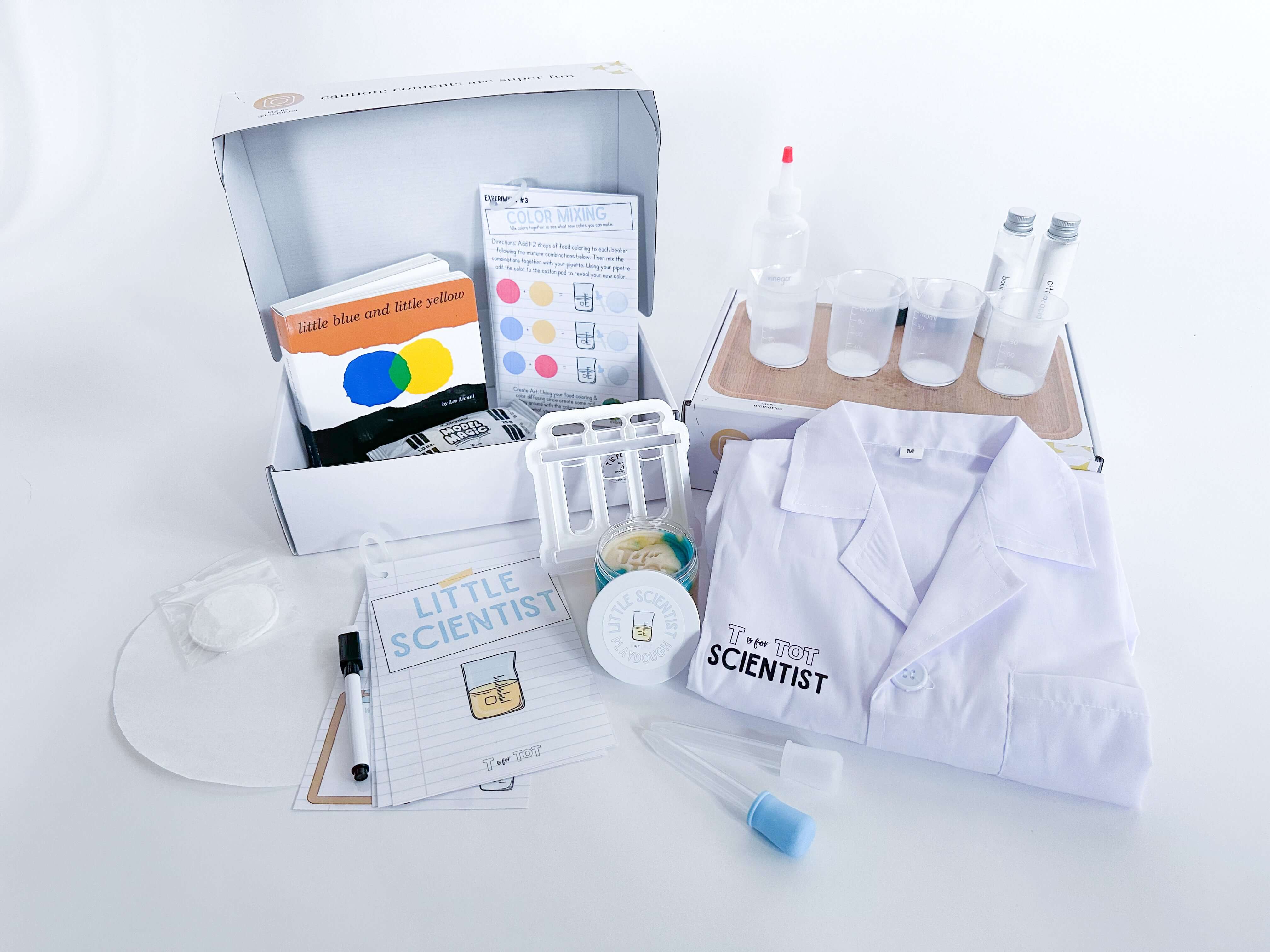 Science play kit for children with lab tools, homemade playdough, and a playdough cutter. Includes a lab coat, experiment guide, beakers, and art supplies for hands-on learning and fun experiments. Great for young aspiring scientists.