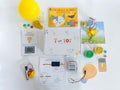 Interactive electricity learning kit for kids, featuring Squishy Circuits battery pack, homemade playdough, and lightbulb playdough cutter. Includes experiments with static electricity and solar panels, along with 