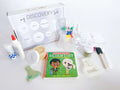 Discovery Kit for kids with homemade playdough and a custom flask playdough cutter. Includes science experiment materials, pattern blocks with build-and-count laminated cards, and art experiment supplies. Comes with a Little Scientist board book, STEAM and recipe card, a detailed brochure, and a box that turns into a Discovery Lab.