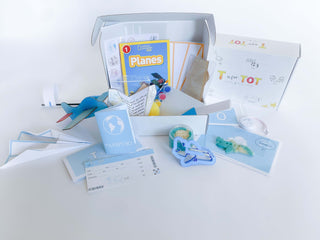Airplane play and learn kit for kids, featuring supplies to construct and create four different airplanes, including a paper airplane, wooden airplane, straw airplane, and constructed airplane. Comes with homemade playdough, airplane playdough cutter, measuring tape, airplane tickets, passport, and a children